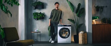 Man die naast een wasmachine staat