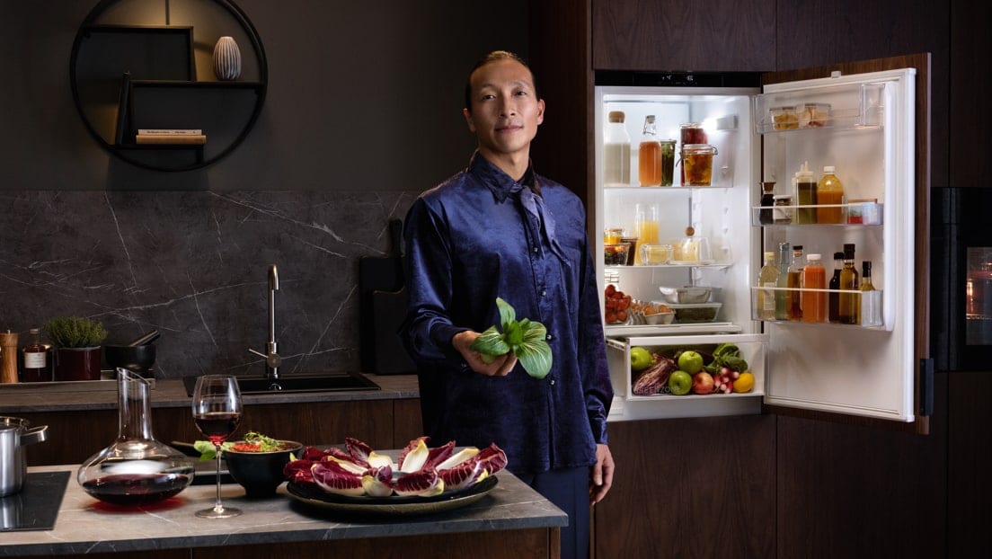 homme devant un frigo/congélateur AEG