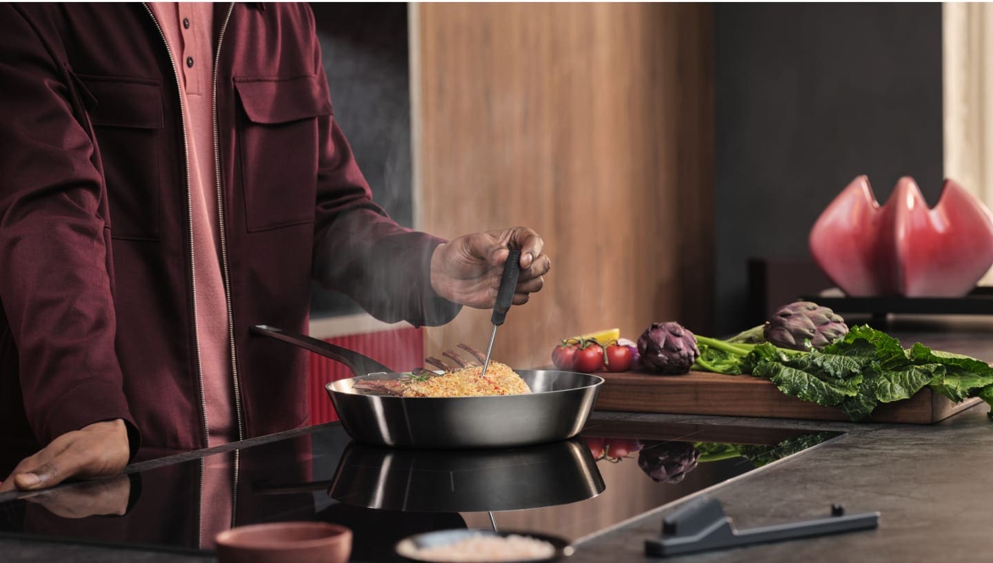 Une personne prépare le dîner sur une taque de cuisson à induction.